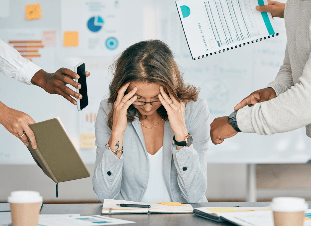 Femme au travail submergée par le stress et les sollicitations, illustrant les symptômes du burn-out avant un bilan de compétences.